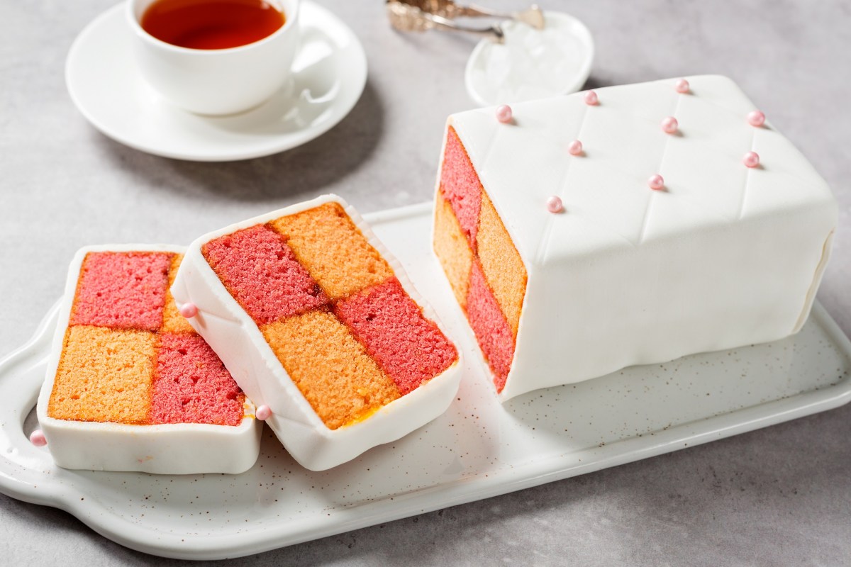 Battenberg-Kuchen mit Schachbrettmuster und eine Tasse Tee.