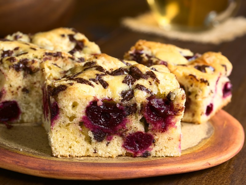 Blondies mit Kirschen auf einem Teller.