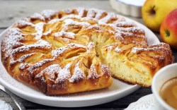 Ein Elsässer Apfelkuchen mit Puderzucker auf einem Teller.