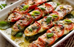 Gefüllte Zucchini mit Mozzarella und Tomaten in einer Auflaufform.