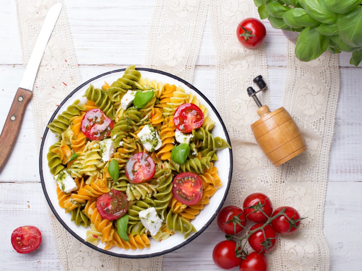 Schüssel mit mediterranem Nudelsalat mit Pesto.