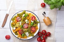 Schüssel mit mediterranem Nudelsalat mit Pesto.