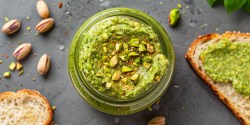 Glas mit Pistazien-Pest und einer Stulle mit dem Pesto bestrichen.