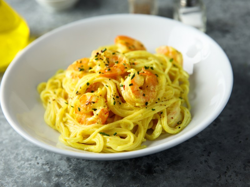 Ein weißer Teller mit Safran-Pasta mit Garnelen