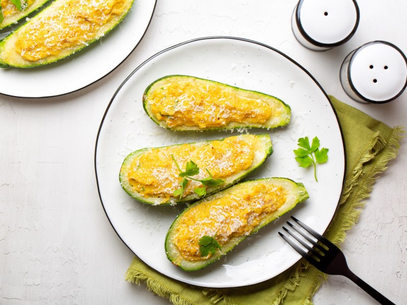 Mehrere Stücke überbackene Zucchini mit Thunfisch auf einem weißen Teller