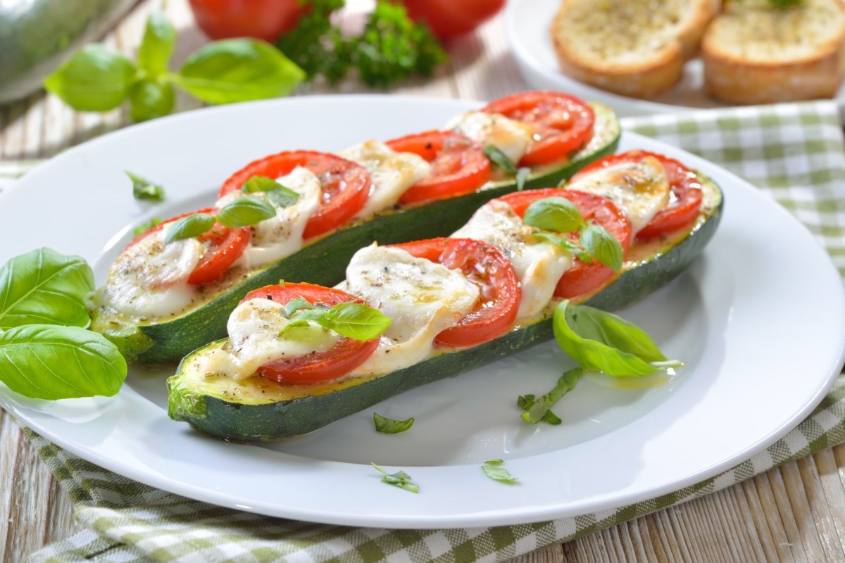 Zwei gegrillte Zucchini mit Tomate-Mozzarella und Basilikum.