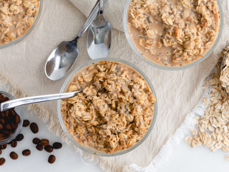 Zwei Schalen mit Kaffee-Overnight-Oats und Kaffeebohnen