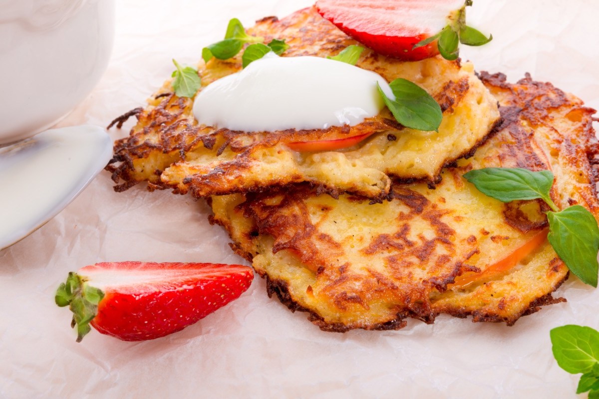 Zwei Kartoffelpuffer mit Erdbeeren und Joghurt.