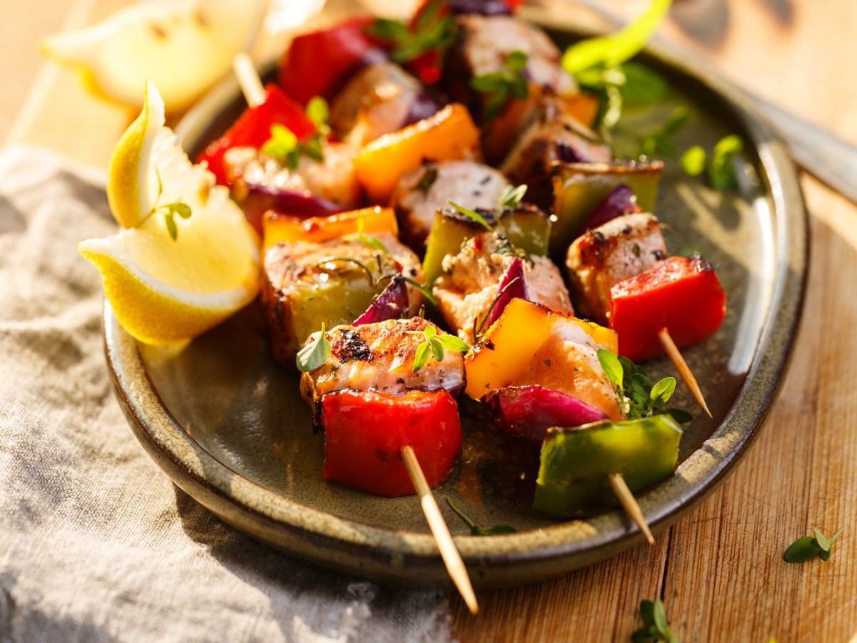 Drei Lachs-Kebab-Spieße vom Grill auf einem Teller