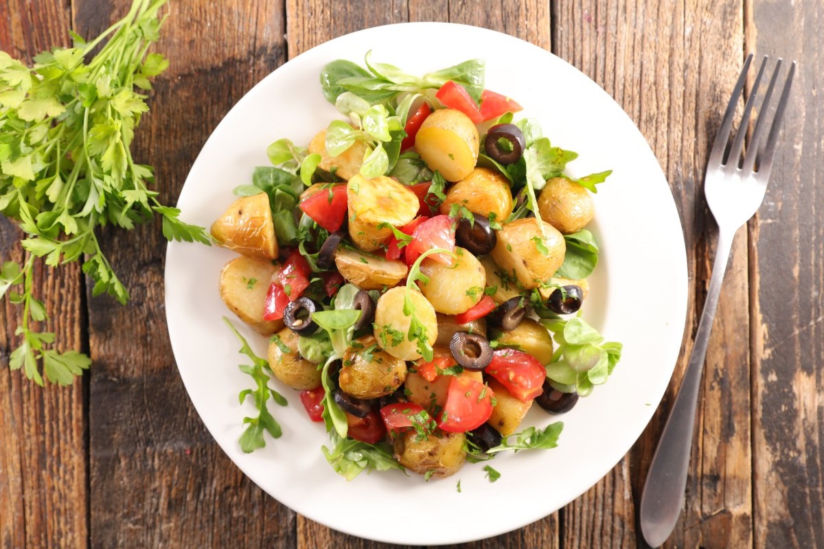 Ein Teller mit mediterranem Kartoffelsalat in der Draufsicht.