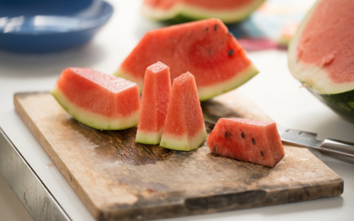 Melone schneiden: mehrere Melonenstücke auf einem Brett.
