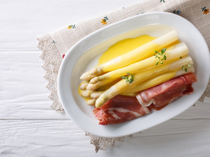 Teller mit weißem Spargel, Schinken und dSafransoße