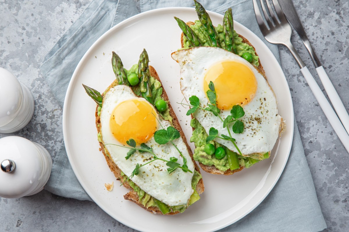 Spargel-Toast mit Spiegelei und Avocado auf einem Teller.