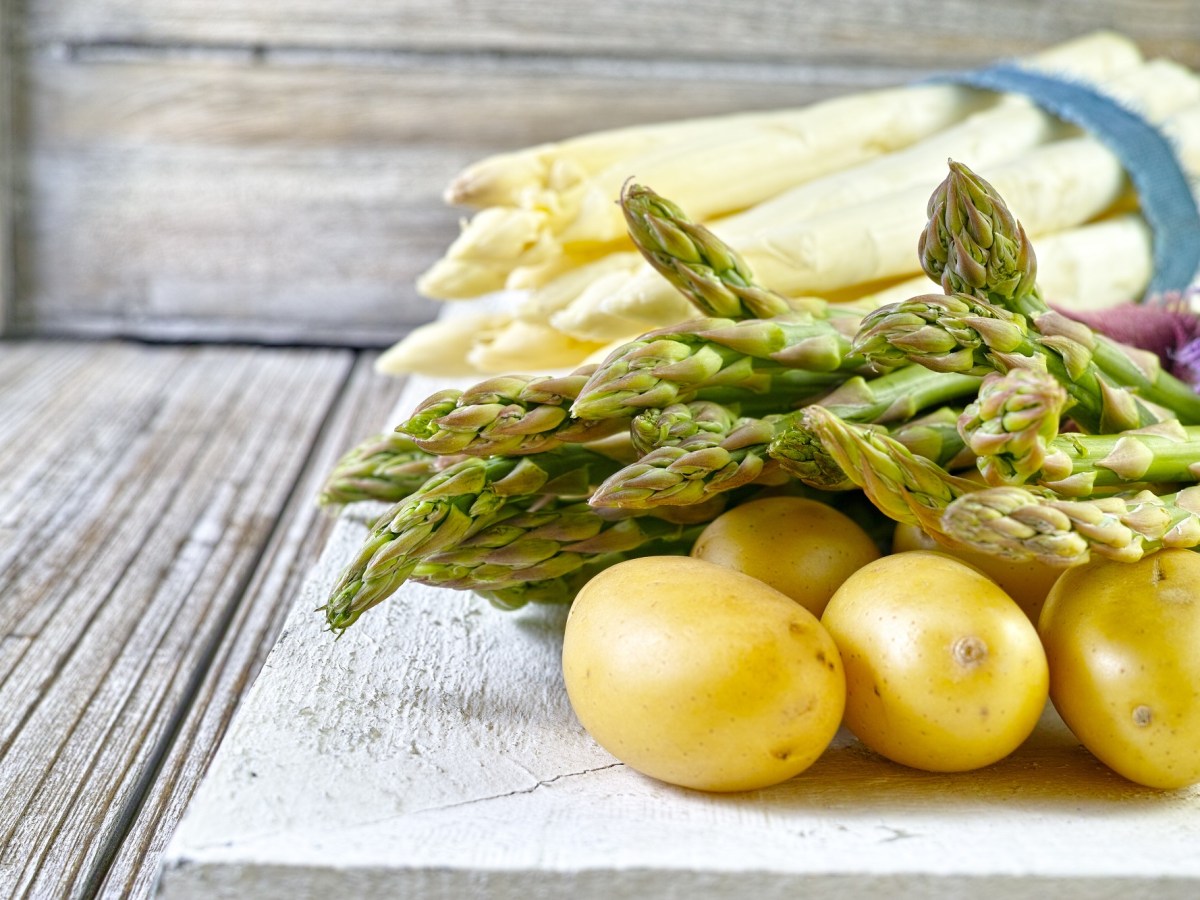 Spargelrezepte: je ein Bund Weißer und grüner Spargel mit Kartoffeln.