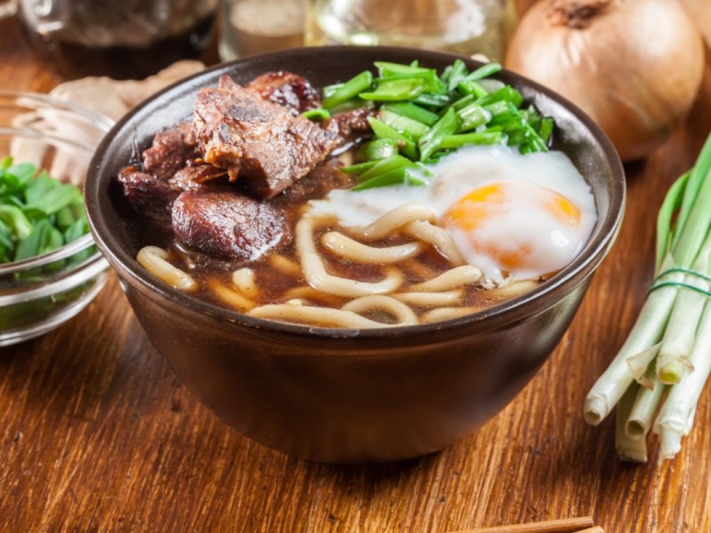 Eine Schüssel Udon-Nudelsuppe mit Ei und Rindfleisch.