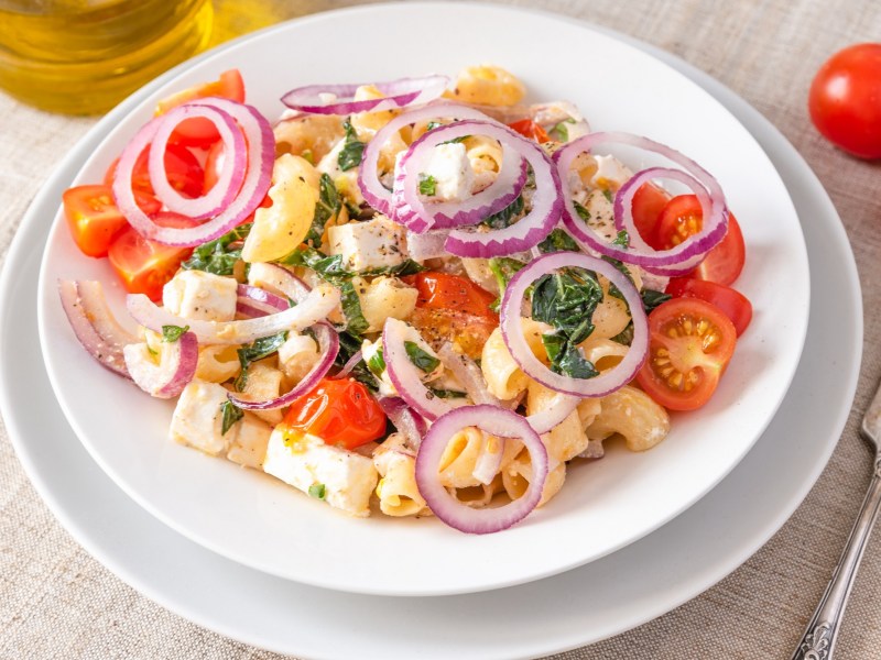 Teller mit warmem Nudelsalat mit Tomaten