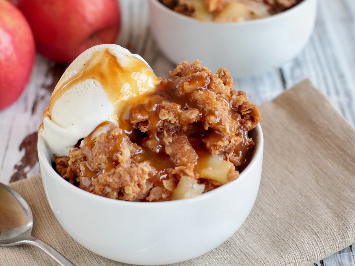 Eine Schüssel Apple-Crisp mit Vanilleeis und Karamellsoße.