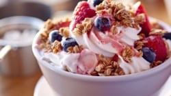 Schale mit Frozen Joghurt, Knuspermüsli und Beeren.