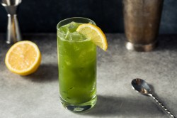 Matcha Tonic in einem hohen Glas, garniert mit Zitrone.