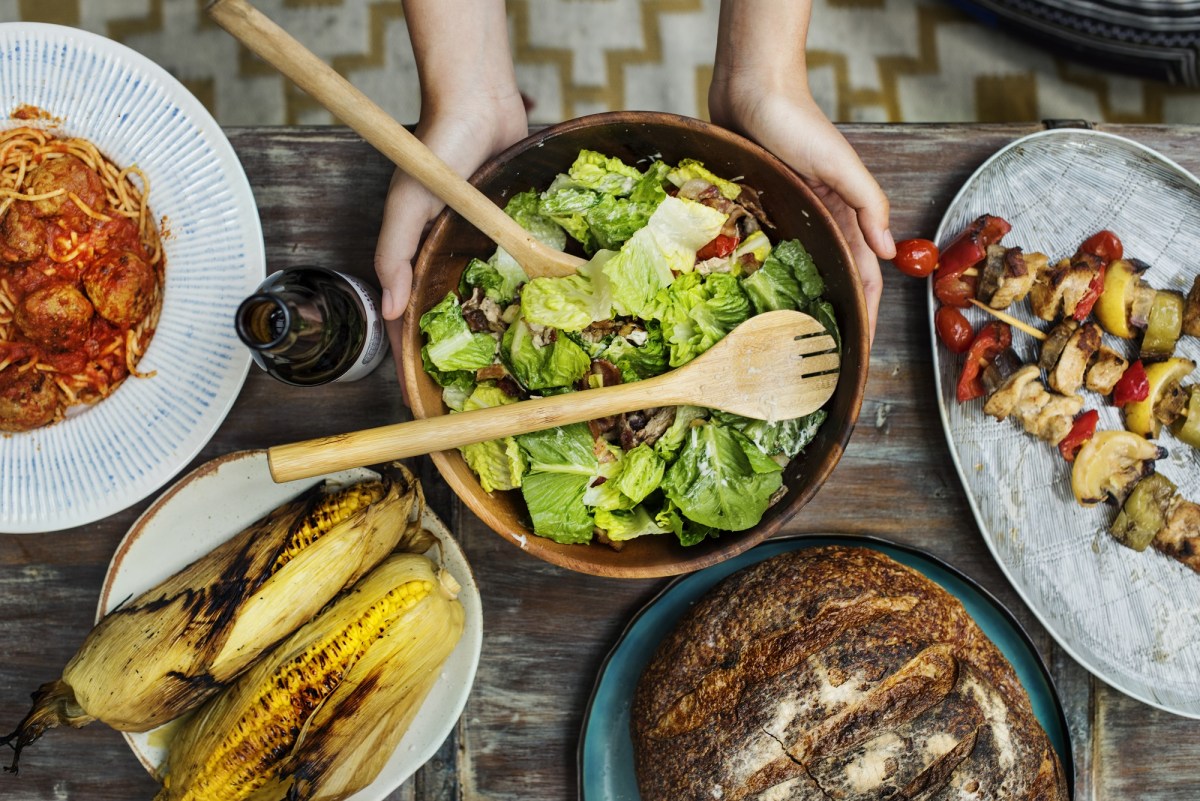 Salate zum Grillen: Grillbuffet in der Draufsicht, darauf u.a.a Mais, Spieße und eine Salatschüssel.