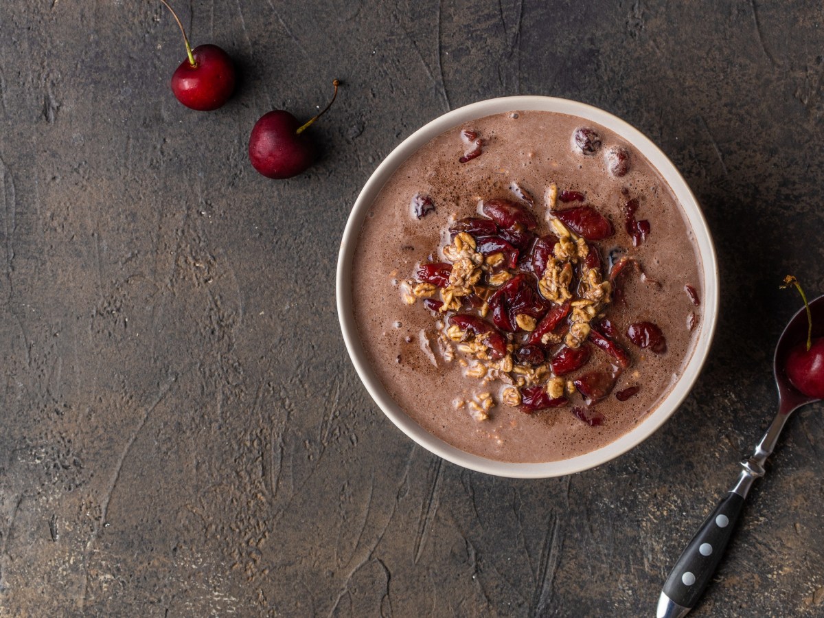 Eine Schüssel Schwarzwälder-Kirsch-Porridge mit Kirschen getoppt, Draufsicht.