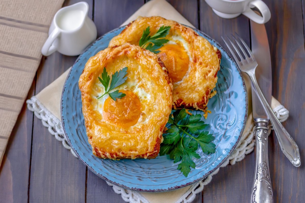 Zwei Spiegelei-Toasts auf einem blauen Teller.