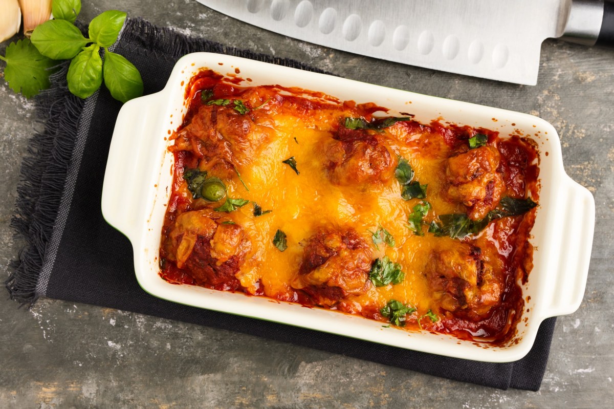 Auflaufform mit überbackenen Hackbällchen in Tomatensoße