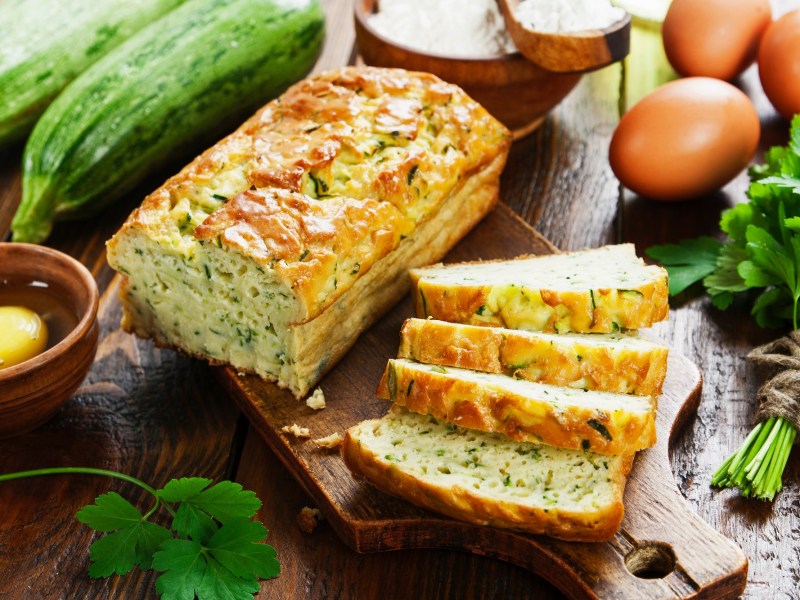 angeschnittenes Zucchini-Feta-Brot auf einem Brett