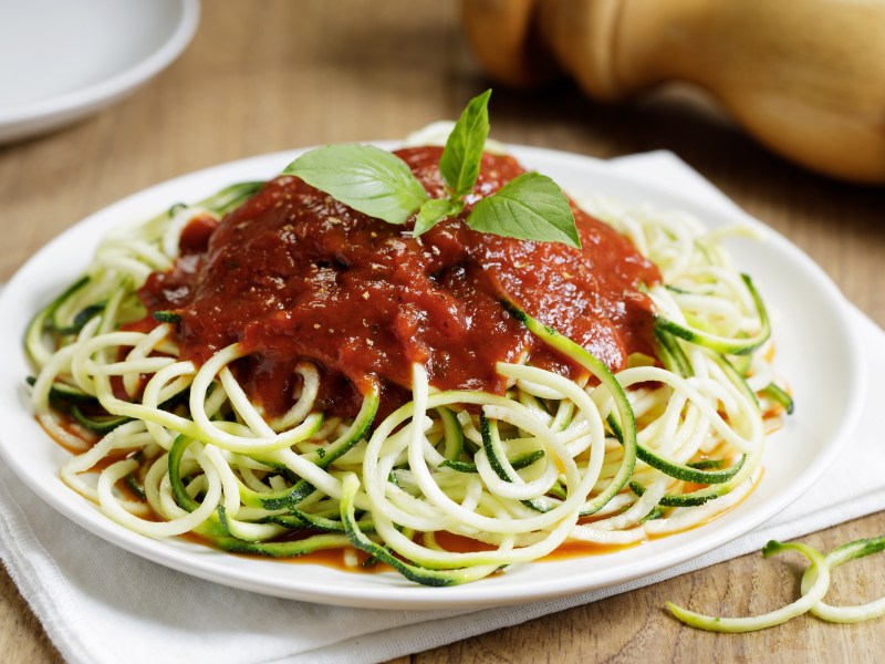 Teller mit Zucchininudeln mit Tomatensoße