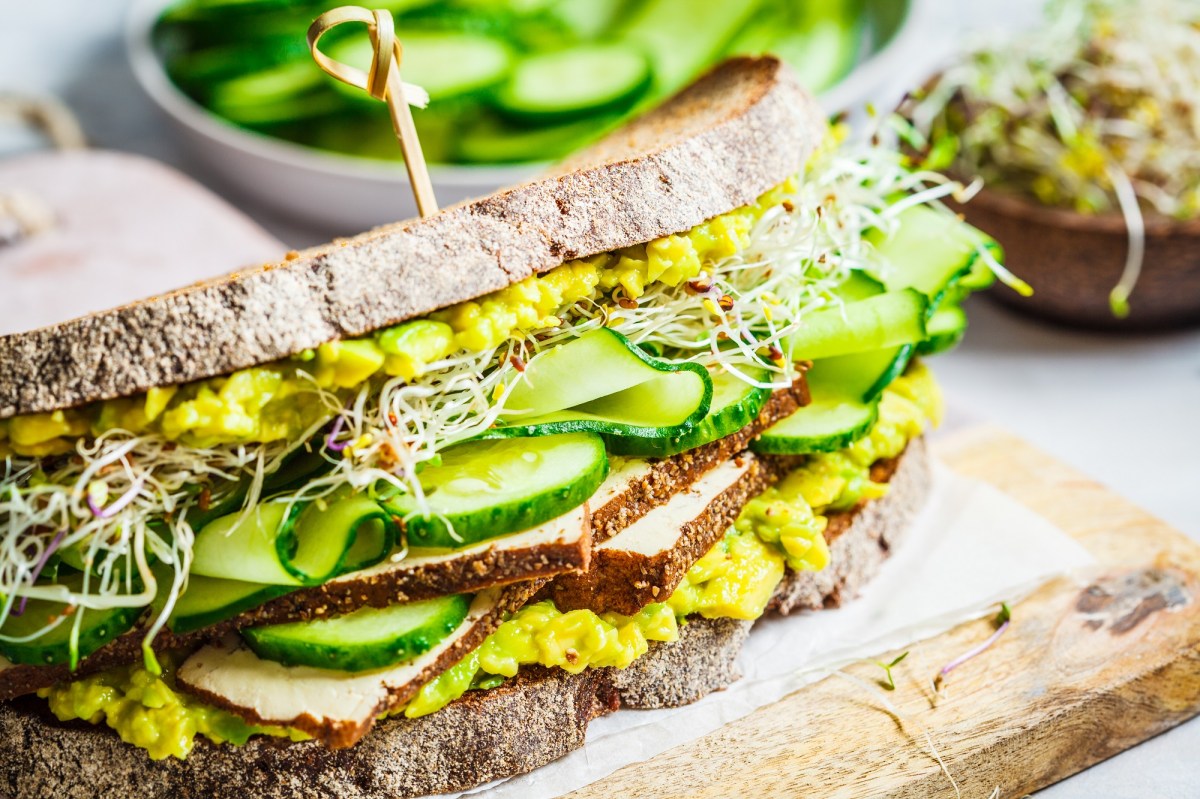 Ein Avocado-Tofu-Sandwich auf einem Brett