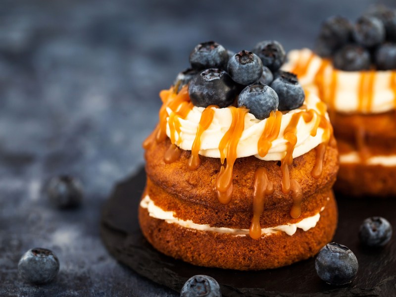 2 Cupcake-Sandwiches mit Heidelbeeren und Karamellsoße verziert.