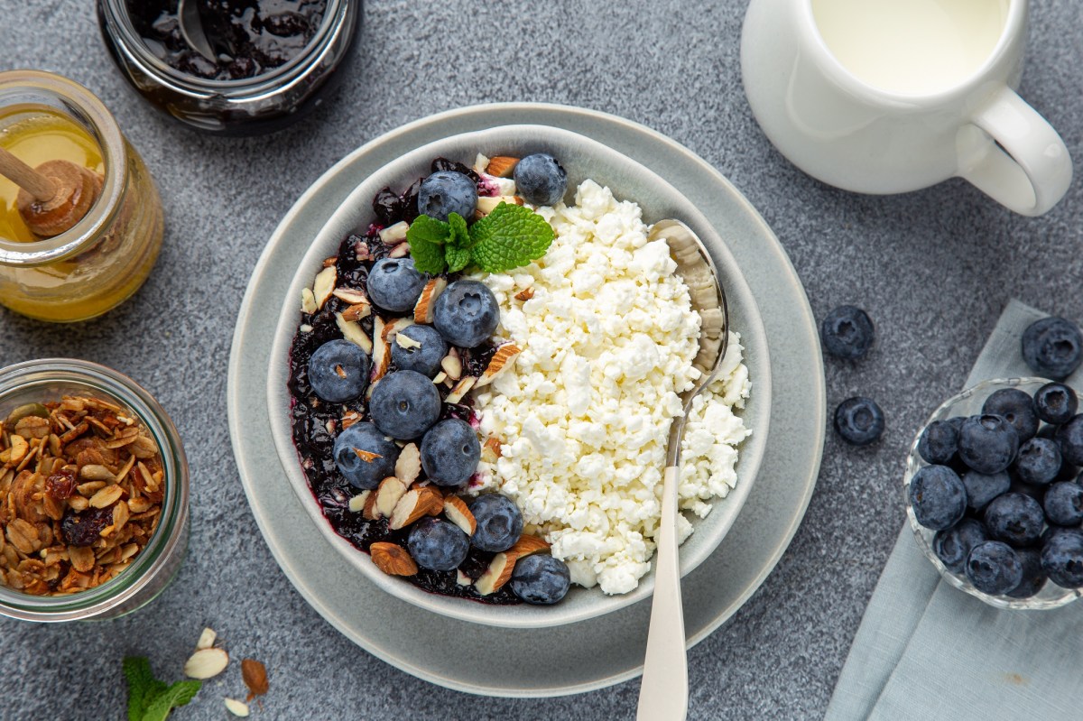 Eine Hüttenkäse-Bowl mit Pflaumenkompott und Beeren.