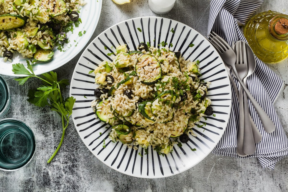 Zucchini-Reissalat auf einem blau-weiÃŸ gestreiften Teller.