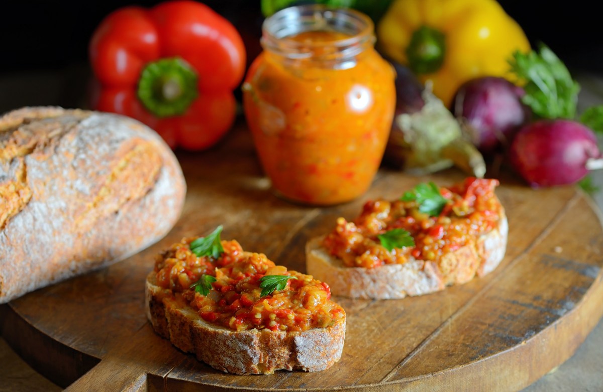 Zwei Scheiben Brot und ein Glas mit Zacusca.