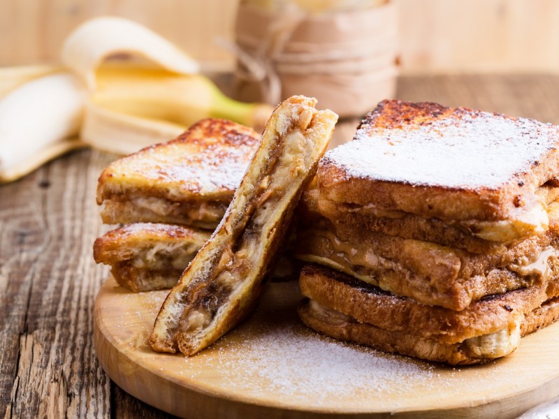 French Toast mit Erdnussbutter und Banane auf einem Brett.