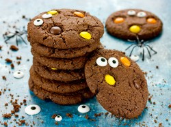 Mehrere Halloween-Monster-Cookies, Plastikspinnen daneben