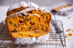 Ein angeschnittenes Kürbis-Nuss-Brot auf eine Kuchengitter.