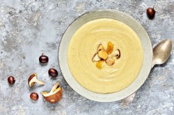 Ein Teller Maronen-Pilz-Suppe, garniert mit Esskastanien und Pilzen.