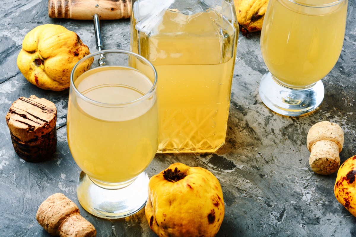 Eine Flasche und zwei Gläser mit Quittensaft