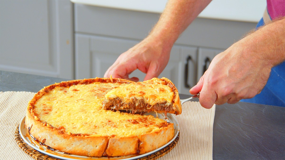 Tiefkühlpizza-Kuchen, aus dem ein Stück herausgenommen wird.