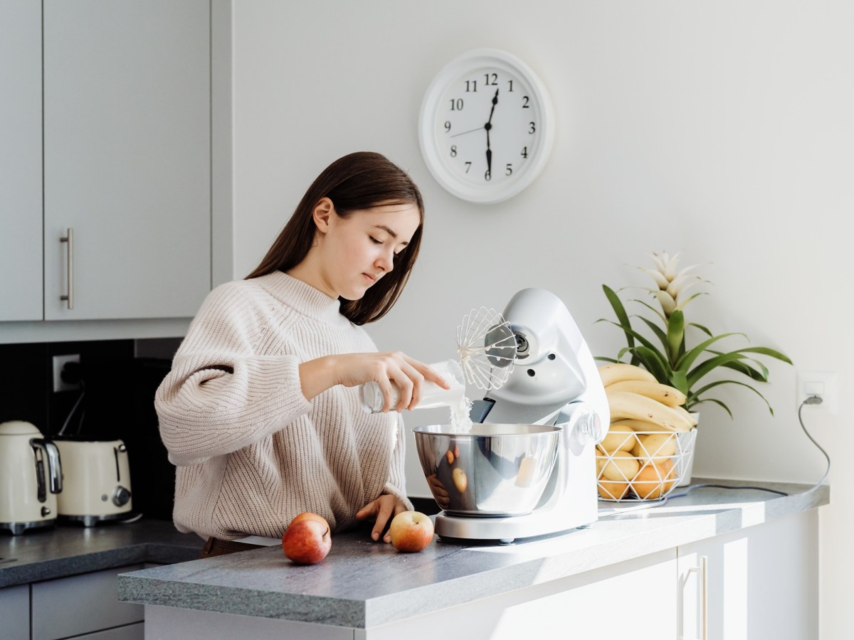 Bosch Küchenmaschine Amazon Black Friday: eine dunkelhaarige Frau in einer Küche an einer Küchenmaschine.