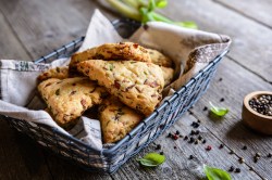 Cheddar-Bacon-Scones in einem schwarzen Brotkorb.