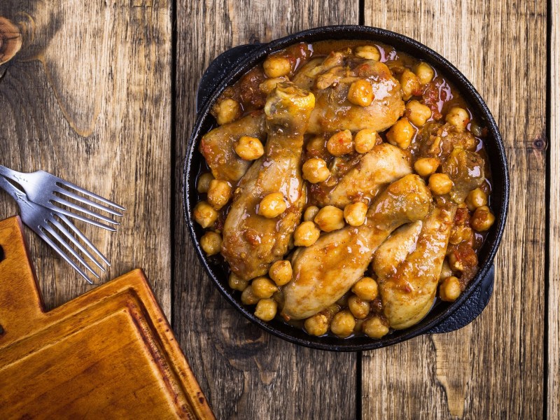 Hähnchenkeulen mit Kichererbsen und Tomatensoße.