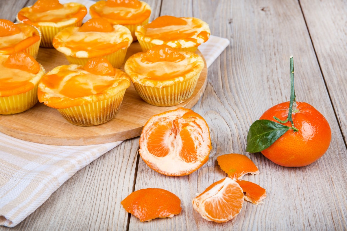 Käsekuchen-Muffins aus der Heißluftfritteuse, davor eine frische Mandarine.