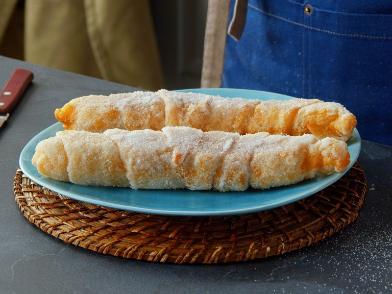 Zwei Milchreis-Churros auf einem Teller.