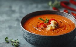 Eine Schüssel Ofenblumenkohl-Suppe mit gerösteter Paprika.