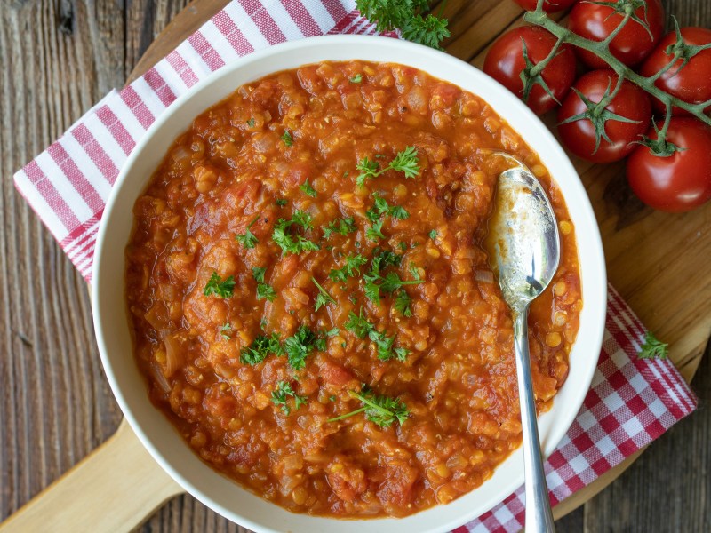 Eine Schüssel Tomatensuppe mit Linsen.