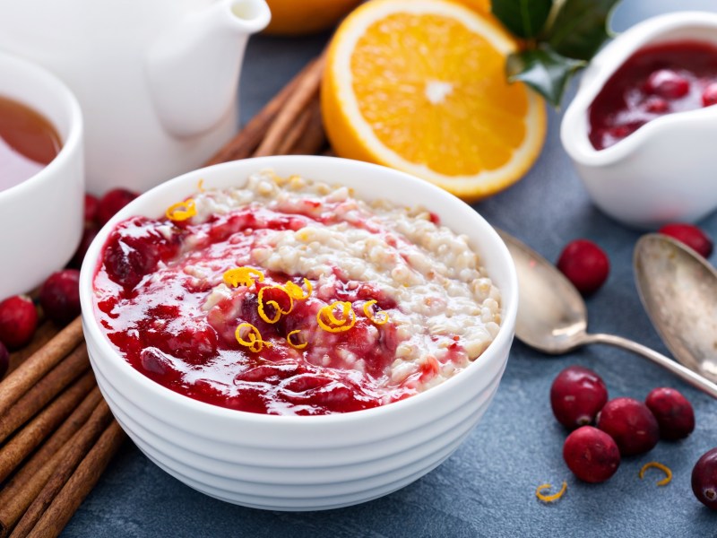 Eine Schüssel Cranberry-Porridge mit etwas Orange.