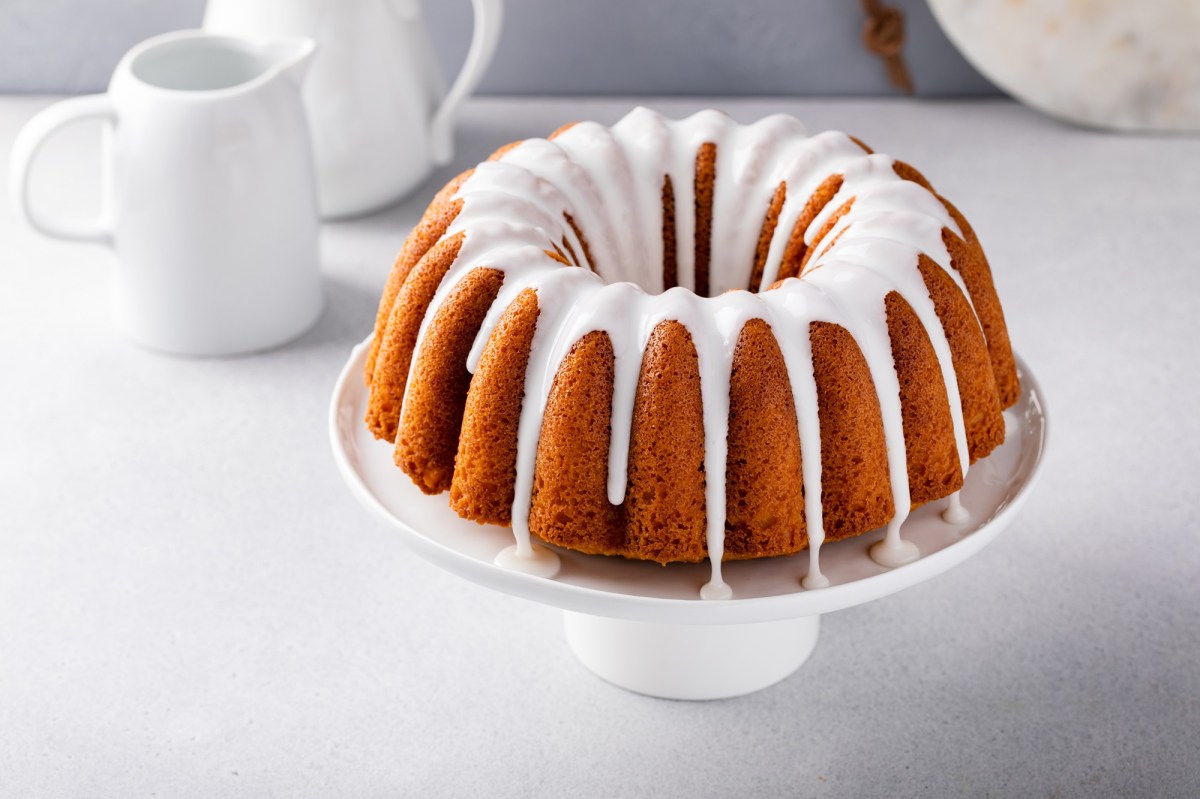 Ein Eierlikörkuchen mit Guss auf einem Kuchentablett.