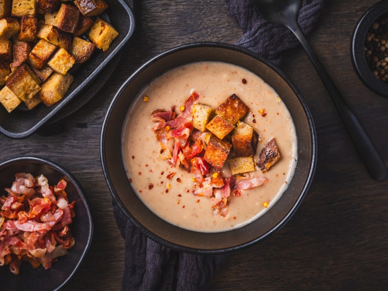 Schale mit Maronencremesuppe mit knusprigem Speck und Croûtons.